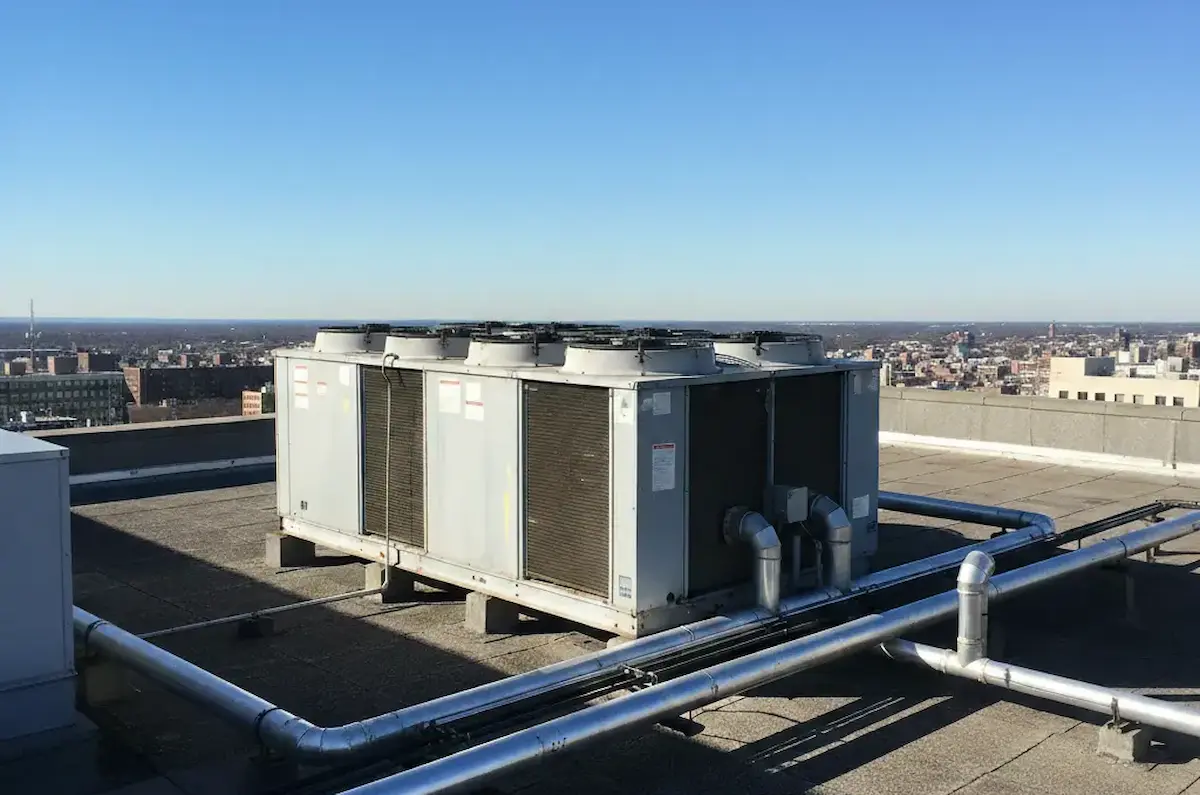 Unidades de aire acondicionado industrial instaladas en la azotea de un edificio con vista a la ciudad